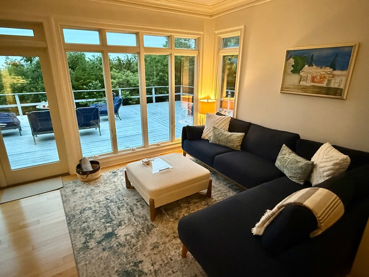 Ocean House villa living room with panoramic Long Island Sound views, coffered ceilings and hardwood floors — luxury vacation rental, North Shore Long Island NY